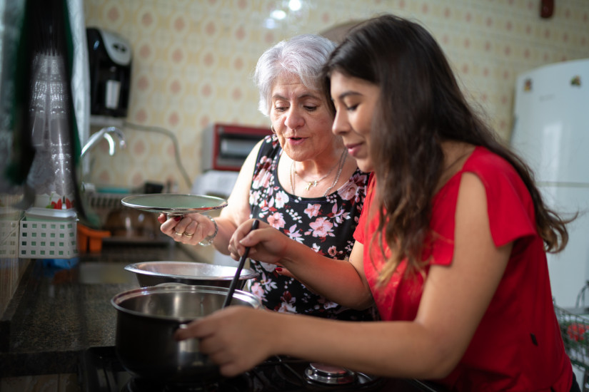 Two women from different generations cook together in a family kitchen